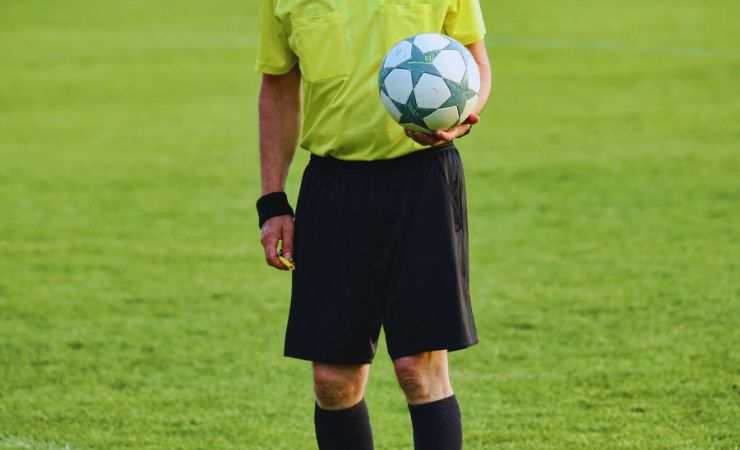 arbitro col pallone in mano